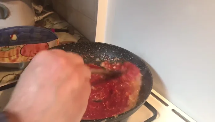 Lasciare cuocere il sugo a fuoco lento per circa 20 minuti, aggiungendo acqua se necessario per mantenere una consistenza cremosa.