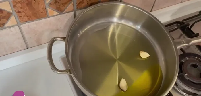 In una padella, preparare un soffritto con olio e aglio, poi aggiungere i calamari ripieni.