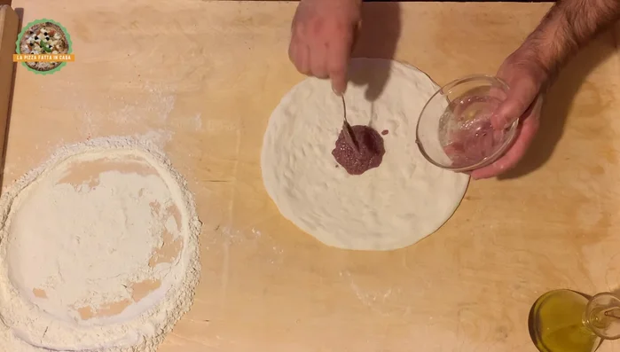 Spalmare la crema di radicchio e speck su tutta la base, lasciando libero il bordo.
