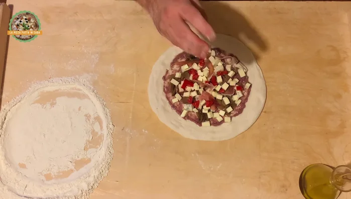 Trasferire la pizza sulla pala e allargarla ulteriormente fino a raggiungere la dimensione desiderata (circa 31 cm).
