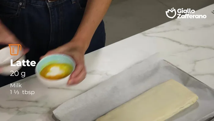 Mescolare latte e tuorlo e spennellare la superficie dello strudel.