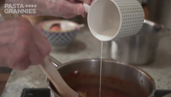 Preparare il sugo: Aggiungere un po' di latte al sugo di funghi (490.919).