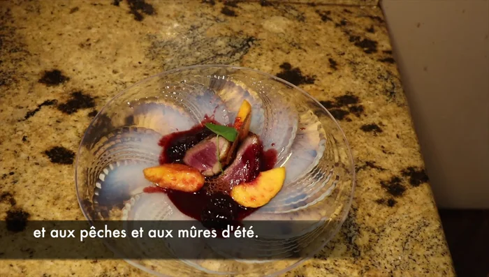 Servi il petto d'anatra con la salsa alle more, guarnendo con pesche mature.
