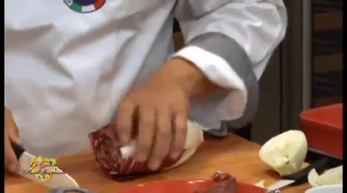 Tagliare il radicchio per l'insalata, rimuovendo la parte dura. Condire con olio, sale, pepe e un pizzico di zucchero.