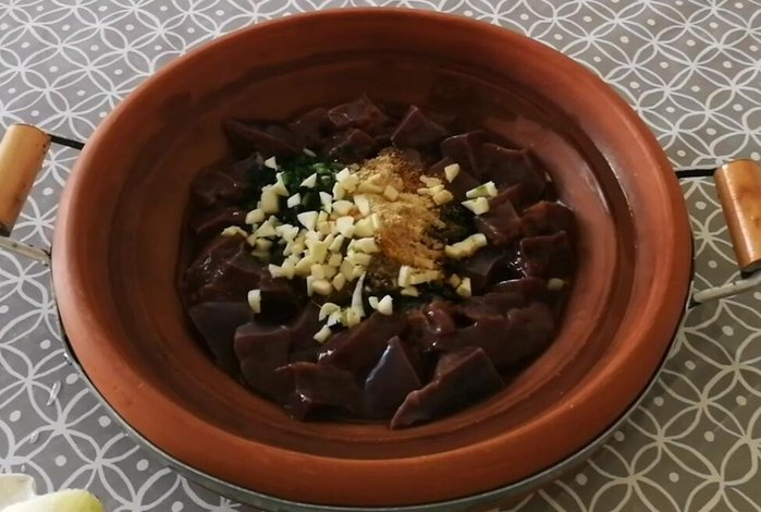 Tritare finemente le cipolle e l'aglio e aggiungerli alla tagine.