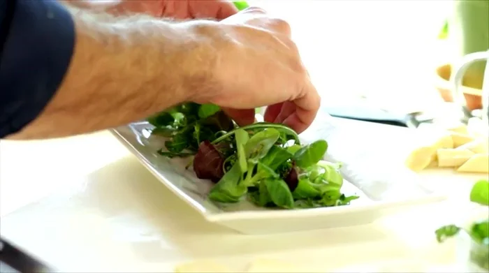 Comporre l'insalata: In un piatto da servizio, disporre la misticanza, i cuori di palma, la toma e lo speck croccante.