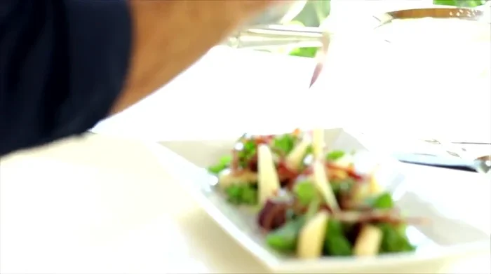 Condire l'insalata con la riduzione al melograno, un filo d'olio crudo e servire.