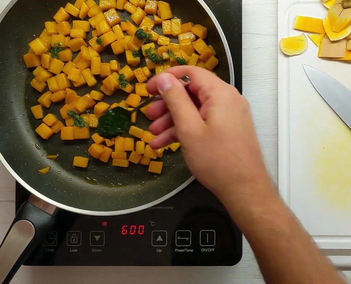 Quando la zucca è ammorbidita, aggiungere l'emulsione di olio, aglio e prezzemolo preparata in precedenza. Saltare la zucca in padella per mescolarla.