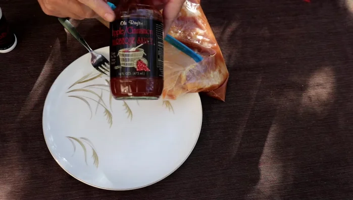 Marinare i petti di pollo: Mescolare la salsa barbecue alla cannella e mela con l'aceto di mele in parti uguali. Immergere i petti di pollo nella marinata. (0:40)