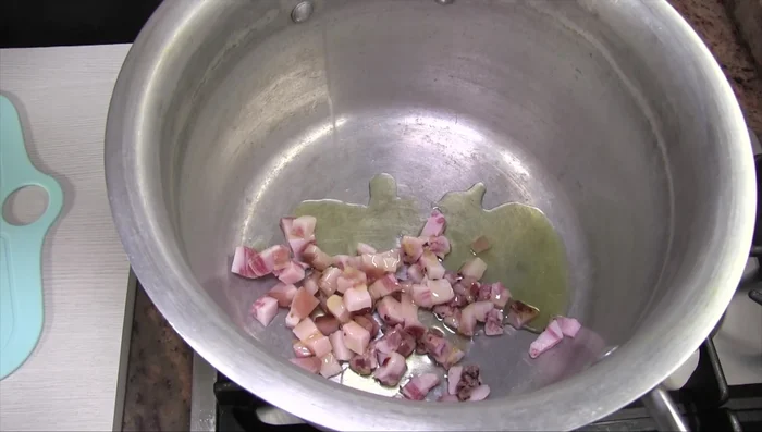 In una pentola con i bordi alti, rosolare il guanciale con un po' d'olio a fuoco basso fino a quando non rilascia il suo grasso.
