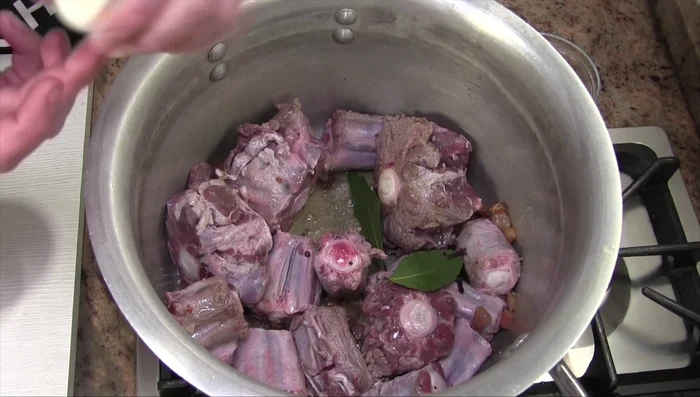 Aggiungere alloro, chiodi di garofano e uno spicchio d'aglio intero (senza pellicina) alla pentola.