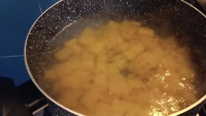 Scolare la pasta un minuto prima del tempo di cottura indicato sulla confezione e versarla nella ciotola con il condimento.