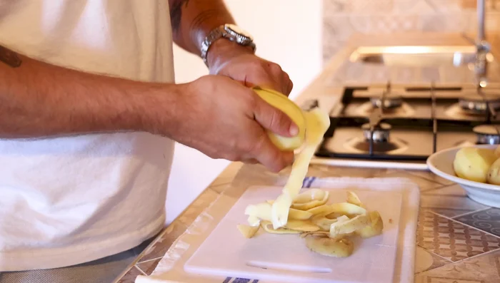 Sbucciare e tagliare a pezzi uniformi 600 grammi di patate.
