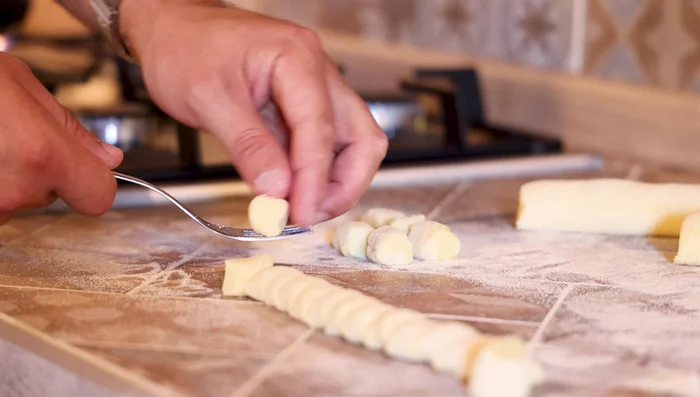 Arrotolare l'impasto su una forchetta o grattugia per creare le righe tradizionali degli gnocchi.
