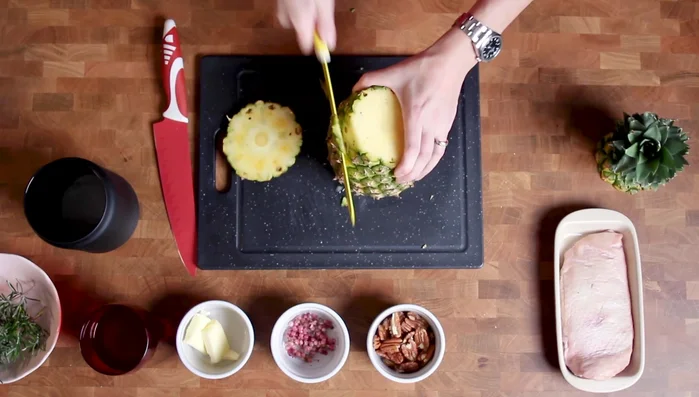 Tagliare l'ananas a fette di mezzo centimetro di spessore. Una parte dell'ananas va tagliata a cubetti piccoli.