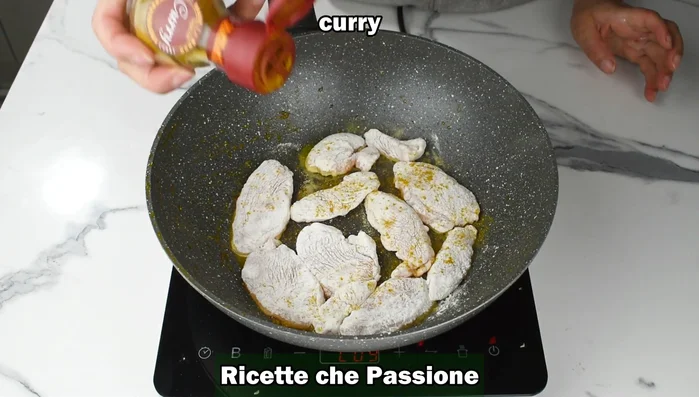 Aggiungere curry e sale. Rosolare il pollo da entrambi i lati.