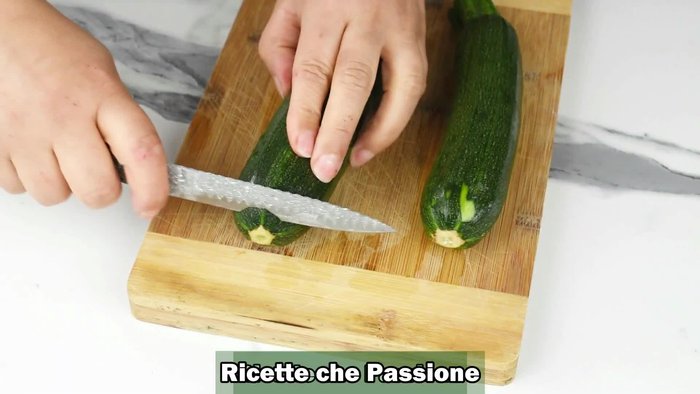 Lavare e tagliare le zucchine a fette spesse circa 1 cm.