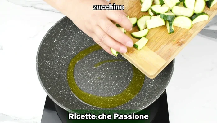 Scaldare l'olio d'oliva in una padella e aggiungere le zucchine. Aggiungere un pizzico di sale e cuocere per qualche minuto con coperchio a fuoco medio, mescolando di tanto in tanto.