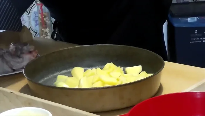 In una teglia, mettere le patate, le cipolle, i piselli, il sale, l'origano, il parmigiano (una parte), il pepe fresco e l'olio d'oliva.