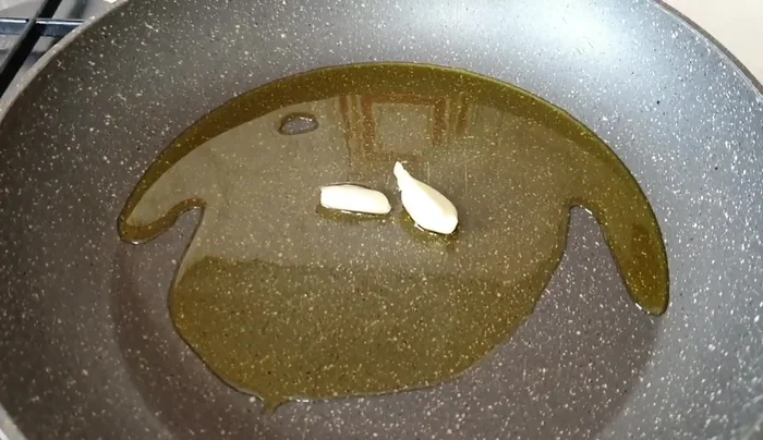 Rosolare l'aglio in una padella con olio.