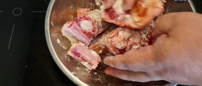 Condire la coda di toro con sale, pepe, paprika affumicata e farina. Mescolare bene per infarinare tutta la carne. (105.52)