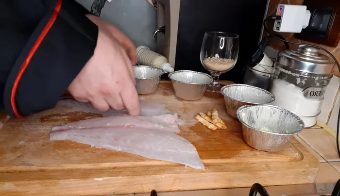 Frollatura e preparazione degli involtini: suddividere i filetti di orata e rivestirli con i grissini salati tritati, usando uno stampino imburrato (227.9)