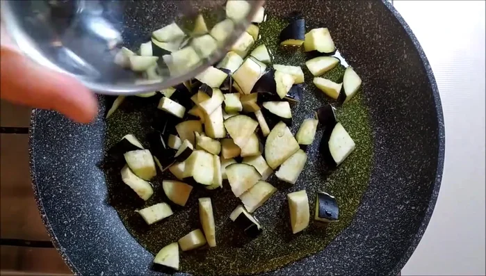 In una padella, soffriggere le melanzane con olio e sale per circa 2 minuti.