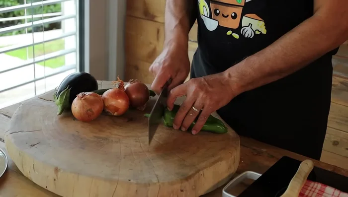 Nel frattempo, preparare le verdure: in una padella, soffriggere le cipolle, la melanzana e le altre verdure a piacere con un filo d'olio. Aggiungere il sale alla fine della cottura.
