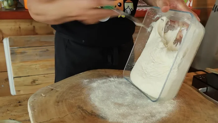 Dividere l'impasto in due parti uguali. Stendere ciascuna parte su una superficie infarinata o direttamente nella teglia, creando due basi per pizza.