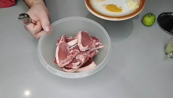 Condire le costolette d'agnello con il composto preparato, assicurandosi che siano ben coperte.
