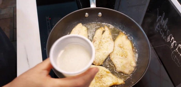 Versare il composto di vino bianco nel padella con il pollo in cottura.