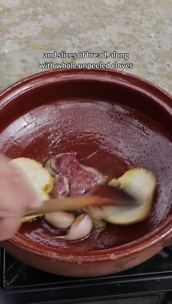 Rosolare in abbondante olio d'oliva il fegato di coniglio e le fette di pane insieme agli spicchi d'aglio interi e non sbucciati.