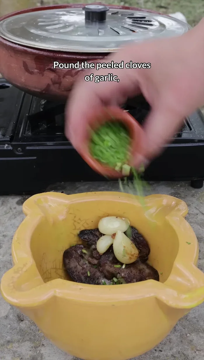 Preparare la salsa: pestare gli spicchi d'aglio sbucciati, il prezzemolo, i crostini fritti, il fegato e le mandorle (per una consistenza croccante).