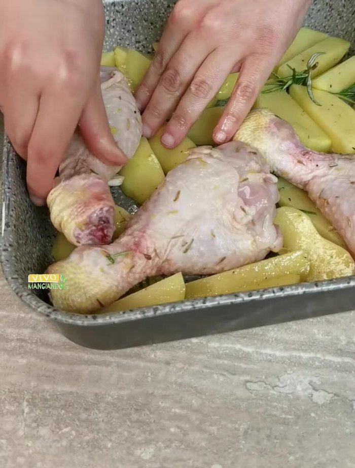 Aggiungere il pollo alla teglia con le patate. Aggiungere la marinatura rimasta, un pizzico di sale, un filo d'olio e il succo di un altro limone.