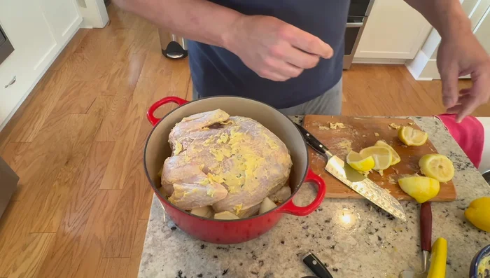 Riempire la cavità del pollo con fette di limone e aggiungere altro burro all'interno.
