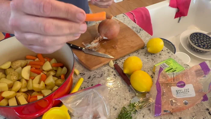 Tagliare le patate a pezzi grandi e le carote a metà. Mettere le verdure sul fondo di una teglia abbastanza grande da contenere il pollo.