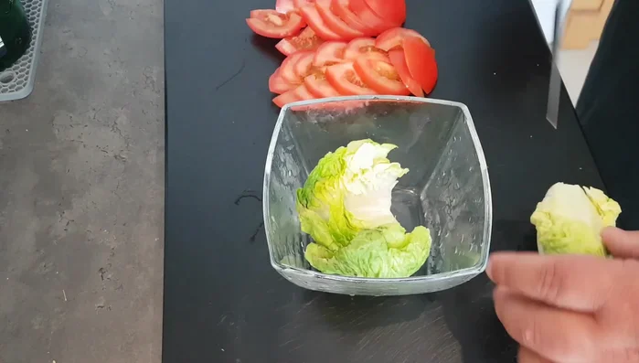Preparare l'insalata: Preparare un'insalata semplice con lattuga, pomodori a fette, un goccio d'olio, sale e basilico (286.08).