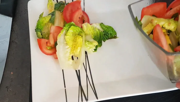 Impiattare: Disporre l'insalata sul piatto, aggiungere le verdure saltate e le braciole grigliate. Condire con un filo di olio extravergine di oliva (423.96).