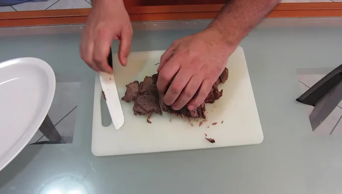 Taglio e impiattamento: una volta raffreddata, tagliare la carne con un coltello affilato. Scaldare leggermente il piatto, versare il sugo sul fondo, adagiare la carne e ricoprire con il sugo rimanente. Servire.