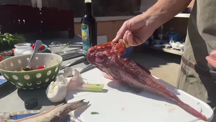 Pulizia del pesce: Pulire accuratamente lo scorfano, rimuovendo le spine velenose. Lasciare le squame sulla tracina per evitare che la pelle si attacchi alla griglia.