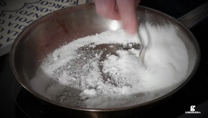 Scaldiamo una padella, versiamo lo zucchero e, una volta caramellato, cuociamo le fette di mela da entrambi i lati.