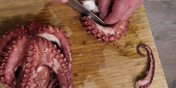 Tagliare il polipo a pezzi e rosolarlo in una piastra ben calda con un filo d'olio extravergine di oliva per renderlo croccante.