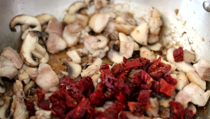 Aggiungere i pomodori secchi (222.9) al pollo e ai funghi, mescolare bene (229.859).