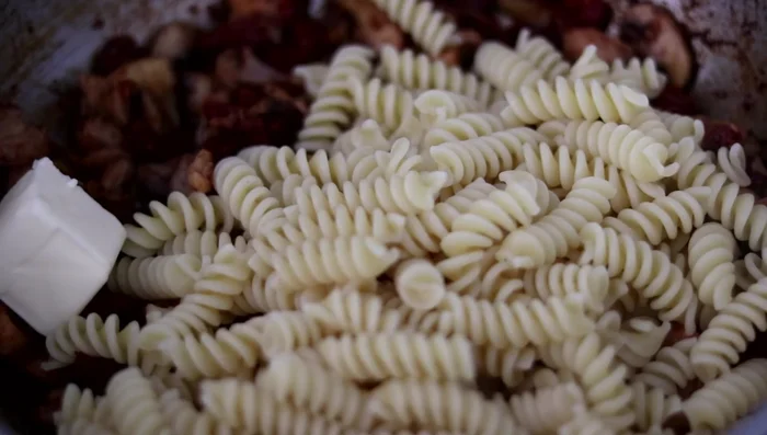 Aggiungere la pasta, burro freddo e un po' di acqua di cottura (341.58). Mescolare (350.79).