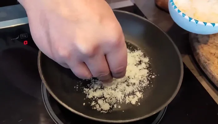 Preparare la cialda di parmigiano: grattugiare il parmigiano e cuocere in padella fino a doratura.