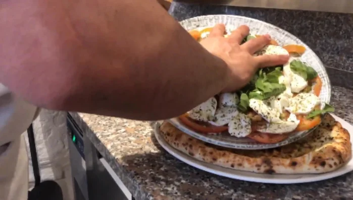 Trasferire delicatamente il composto di mozzarella e pomodori sulla focaccia lievitata.
