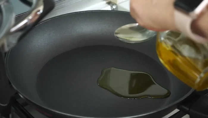 In una padella, mettere 2 cucchiai di olio, l'aglio intero e sbucciato (92.52).