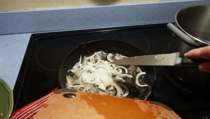 Cuocere le cipolle: Aggiungere le cipolle affettate nella padella e cuocere per 4-5 minuti, fino a quando saranno morbide (351.979).