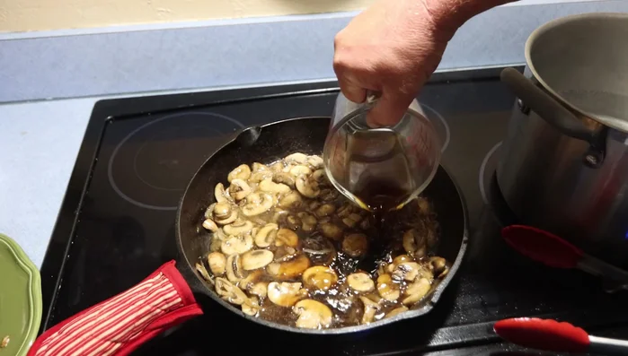 Sfumare con il Marsala: Aggiungere il vino Marsala e far sfumare, raschiando il fondo della padella per raccogliere i residui (489.599).