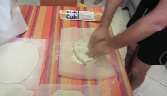 Stendete la pasta per pizza su una superficie infarinata, partendo dal centro e dirigendovi verso i lati. Continuate ad allargare la pasta fino a raggiungere lo spessore e la dimensione desiderata.